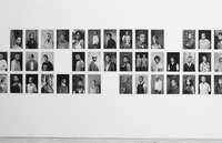 Three rows of Faces and Phases photographic portraits (forty-two total) displayed in a gallery, with three noticeable gaps where portraits should be. The portraits are similarly staged, with each subject looking directly into the camera’s gaze.