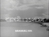 After the opening titles, the place and time "Varanaras—1920" are introduced in both the original Bengali and in English transliteration. This is over a screenscape of a river.