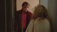 Man with disheveled hair and running makeup at an apartment door