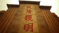 A retention wall has red calligraphy written on it.