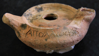 Fig 61: Inscribed Material from Bīr Shawīsh 3 is a ceramic oil lamp with the name Apollos. Lamp is having dimensions of height at 30.6 mm, handle to spout length at 103 mm, central hole diameter at 16.6 mm.