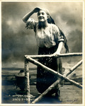 Black-and-white photograph of actress Sonia Alomis leaning on a fencepost and looking out into the distance.