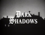 Title screen with white english text reading "Dark Shadows" is superimposed over a black and white image of a silhouette of a building.