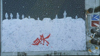 A large red calligraphy character is painted on a a painting on top of white and yellow calligraphy characters spread across a white abstract background, below a starry sky.