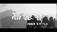 A mountain view has white calligraphy and English numerals superimposed over it, in black and white cinematography.