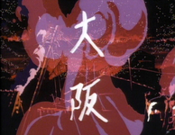 White calligraphy for "Osaka" is superimposed over a series of explosions, flames, and a smoke plume in a residential district.