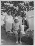 In this black-­and-­white vacation photo, two adults and two teens are sitting under a large tree by a lake. In the middle in the front, sitting on a rock, is Wang Wenxing, a white-­clad preteen, wearing a sailor’s hat, a sleeveless knee-­length checkered dress, tights, and sneakers. She is holding a book on her knees. Chen Bijun, round-­faced and bespectacled, rests her left foot on a rock, her short hair cropped to the ears. She is wearing a long white dress, tights, and sneakers. Wang Jingwei, in a dark suit, is sitting sideways on the rock behind his daughter and wife, turning his head to the camera. Wang Wenying, wearing a Basque-­style beret and jacket but white shirt, pants, and shoes, also rests his left foot on the rock toward the camera. Sunshine casts spots of light on the ground. No one is smiling.