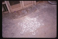 Chalk drawings known as rangoli decorate the front of the household entrance.