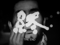 A man's face has white calligraphy reading "The End" superimposed over it, with transliterated white English text beneath it.
