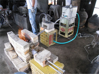 中央に構築した炉の右側にあるのが送風装置，炉から右手前側に炉内観察と温度測定用の2本の耐熱ステンレスパイプがみえる。