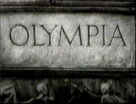 German title text is carved into stone, in black and white cinematography.