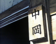 Closeup of a wooden nameplate with the name of the family that lives in this house.