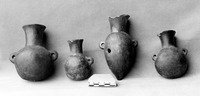 A photo of four miniature Camacho Black Vessels on display in a museum in Peru in 1985.