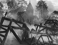 Smokey air, with a church and trees behind a broken fence