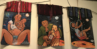Photograph of series of huipiles representing the experience of being pregnant, giving birth, being a mother, and parenting. The first huipile includes an image of a brown woman holding her newly born child. She lovingly stares at her child as she holds her belly with her legs wide open for birthing. The second huipile includes a brown woman wearing a green sweater, black top, and necklace holding a bottle of Lone Star beer. Her toddler also holds it to his mouth as if teething. The third huipile includes a child joyously swaying on a swing wearing a space helmet. The background of these three huipiles is covered with stars and planets that add a galactic dimension.