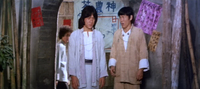 A variety of posters with calligraphy can be seen behind the two main characters.