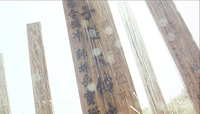 Vertical calligraphy on wooden posts.