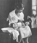 This photograph depicting the “intelligent care” urged on Black mothers has a deliberate ambiguity. The woman staring down at her sleeping child after giving him his bath is softly lit against deep shadows. Her individual features are less important than the washing tub and clean towels in the foreground, and she appears to be wearing a nursing uniform as if to suggest that the good sanitary mother should also be a trained nurse.