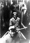 Fig. 3. Zora Neale Hurston wearing a sweater and hat in front of a boat being rowed through a swamp by a black man wearing a cap and sailor-like clothing. Both are smiling.