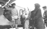 Peasants disembark from an airplane following an aerial baptism, ca. 1925.