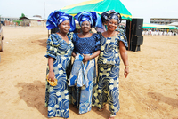 Three women wearing blue and gold aso ebi.