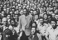 Fig. 5.2. Robeson, a tall and dignified black man wearing a double-breasted suit, with mouth open to sing, is surrounded by a dense crowd of casually dressed men of various skin tones.