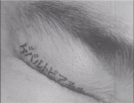 The title of the film, painted on an eyelid.