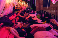A scene of people sleeping in a giant bed at a twenty-­four-­hour performance of Taylor Mac’s show, A 24-­Decade History of Popular Music.