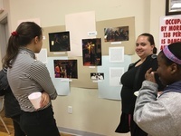 Students and Melrose Residents discuss the images and text on the wall as part of the Boricua College exhibit.
