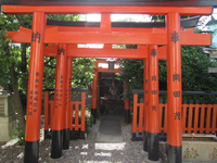 Photograph of red torii gates and small altar.