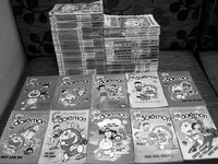 Two stacks of unlicensed books from Kim Dong Publishing. Ten books labelled “Doremon” are laid out with the covers facing up.