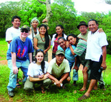Eleven people pose for a group photo together in the high rain forest.