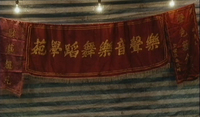 Gold writing on a red banner. Has the name of a dance school