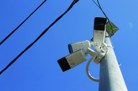 Close view of three security cameras pointing different directions.