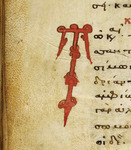 A small portion of a tan parchment with Greek lettering in red. An inscription is on the left side.