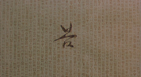 A large black calligraphic character can be seen behind a dense foreground of vertical smaller characters.