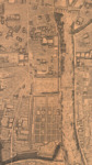 Section of a map of Paris, from a bird’s eye view. On the right is the Seine, with several boats along the bank. In the center are the Louvre and the Tuileries, connected along the bank of the Seine but not connected along the opposite side. Below the Tuileries palace are its gardens.