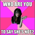 A white woman with long dark hair and thick glasses smirks at the camera and shows off the word “NERD” written on the palm of her hand. She has been photoshopped onto a pinwheel background with varying shades of pink. Top text reads, “Who are you.” Bottom text reads, “To say she’s not?”