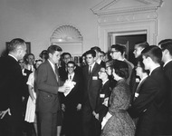 Figure 1. President John F. Kennedy holds a paper in his hand while speaking with a young Bob Axelrod. Other students look on in the background.