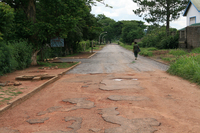 Photograph of a potholed road partially filled in with flux stone sourced from the mine dumps.