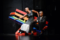 Fig. 5. Rainbow-colored bench tipping on a fulcrum. Formally dressed woman and man share bench. He’s pensive; she’s reaching out to the left, eyes closed.