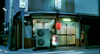 A closed shop is surrounded by banners, a lantern, and signs with black, red and white calligraphy.