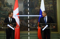 Colored photograph. Sergey Viktorovich Lavrov on the right, Jeppe Kofod on the left looking at each other. Russian flag behind Lavrov, Danish flag behind Kofod. Two lecterns in front.