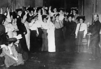 "Women Raise Their Hands Voting for a Strike" (from UNITE Archives, Kheel Center, Cornell University, Ithaca, NY 14853-3901). As a male union official looks on, female rank-and-file pledge to walk the picket lines. The scene dramatically displays women's commitment to union activism, as well as the gendered inequality of the ILGWU.
