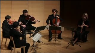 Quintet performs on a small stage.