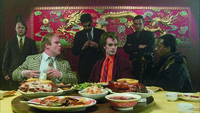 Gangsters seated and standing around a table in a Chinese restaurant