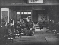 The scroll painting in the tokonoma in the far background tips the balance of the composition. Note that, unlike most Korean films, the screens behind the actors are pictorial and not callligraphic.