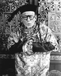 Photograph of Lon Chaney made up as an old Chinese man wearing a traditional Chinese-­looking robe and a hat
