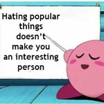 Kirby pointing to text on a white board that reads, “Hating popular things doesn’t make you an interesting person.”