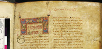 A tan piece of parchment with Greek lettering in red. The letters are given in two columns. The parchment has a small ornamentation above its left column. A color bar is on the left side.